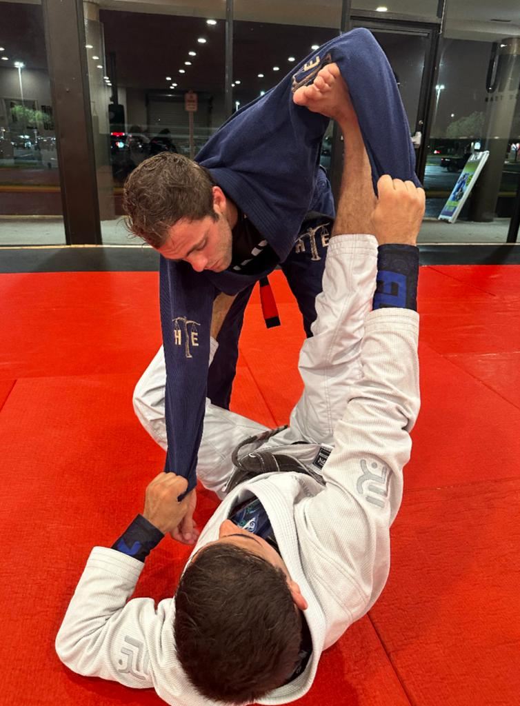When doing spider guard with the right leg, put your left foot on your training partner's hip and hold their sleeves to improve resistance in the grip.