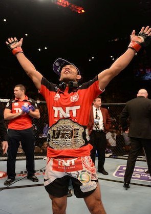 Aldo ergue os braços após receber o cinturão de Dana. Foto: UFC/Facebook