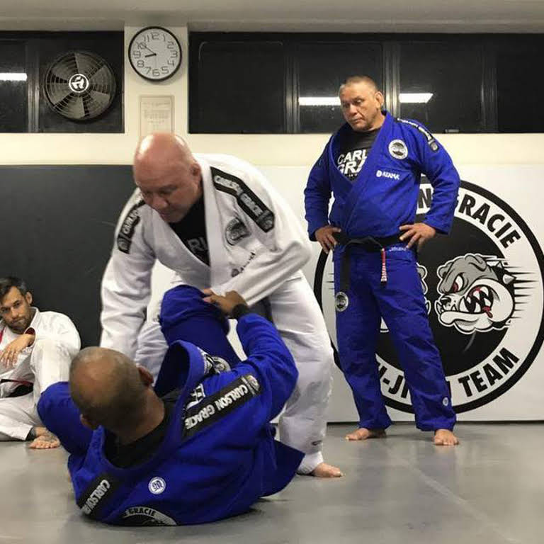 Sérgio Bolão observa a lição de Carlson Gracie Jr, de kimono branco: décadas de peripécias e aventuras. Foto: Divulgação